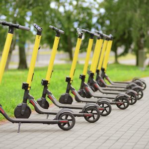 Yellow motorized scooters arranged in a row.